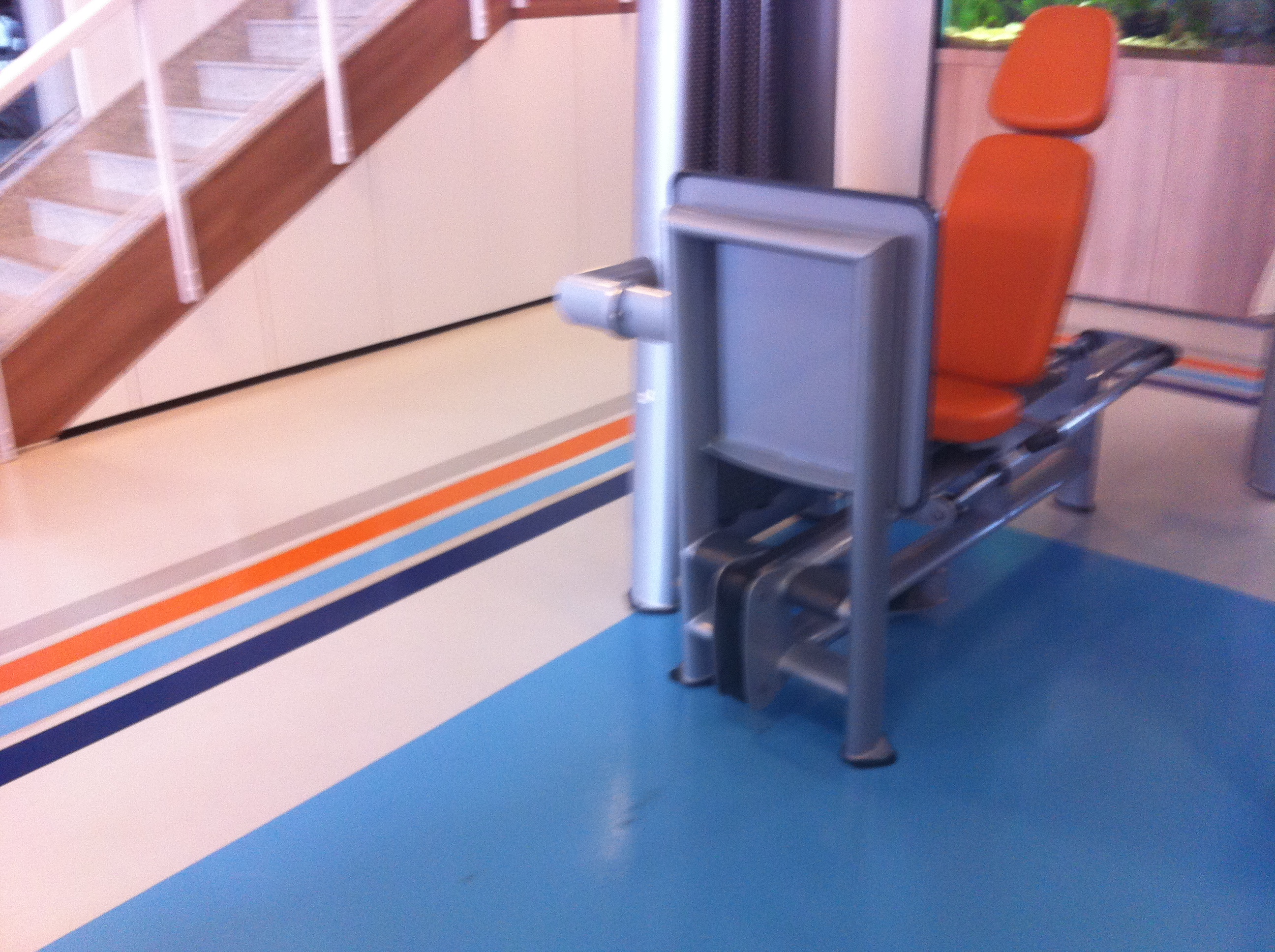 Detalhe do piso em resina colorido de academia, com faixas de demarcação e acabamento de alto brilho.