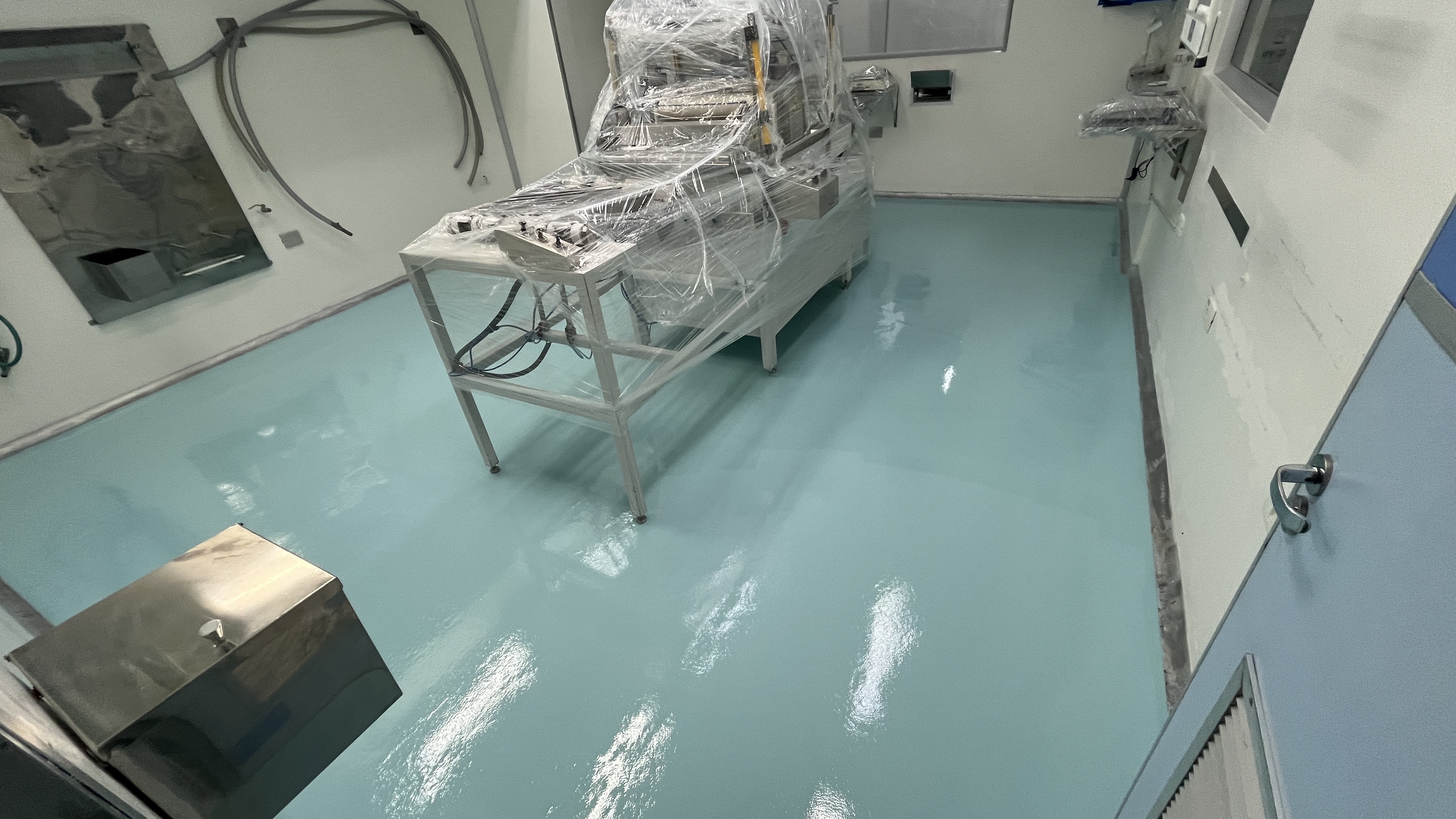 Trecho de laboratório com piso autonivelante recém-aplicado, acabamento liso e uniforme.
