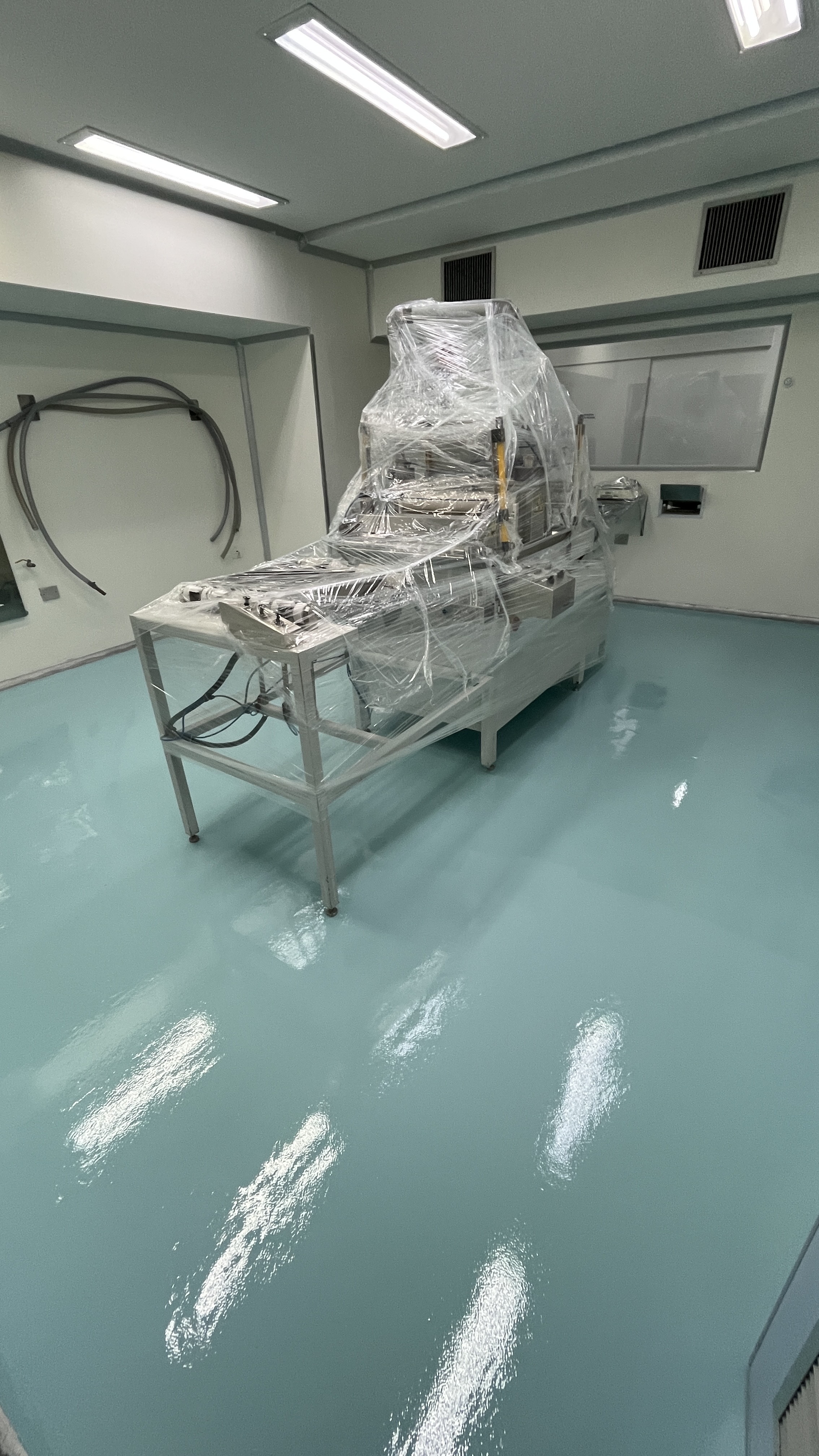 Detalhe de piso autonivelante em ambiente hospitalar, mostrando o acabamento contínuo junto ao rodapé.