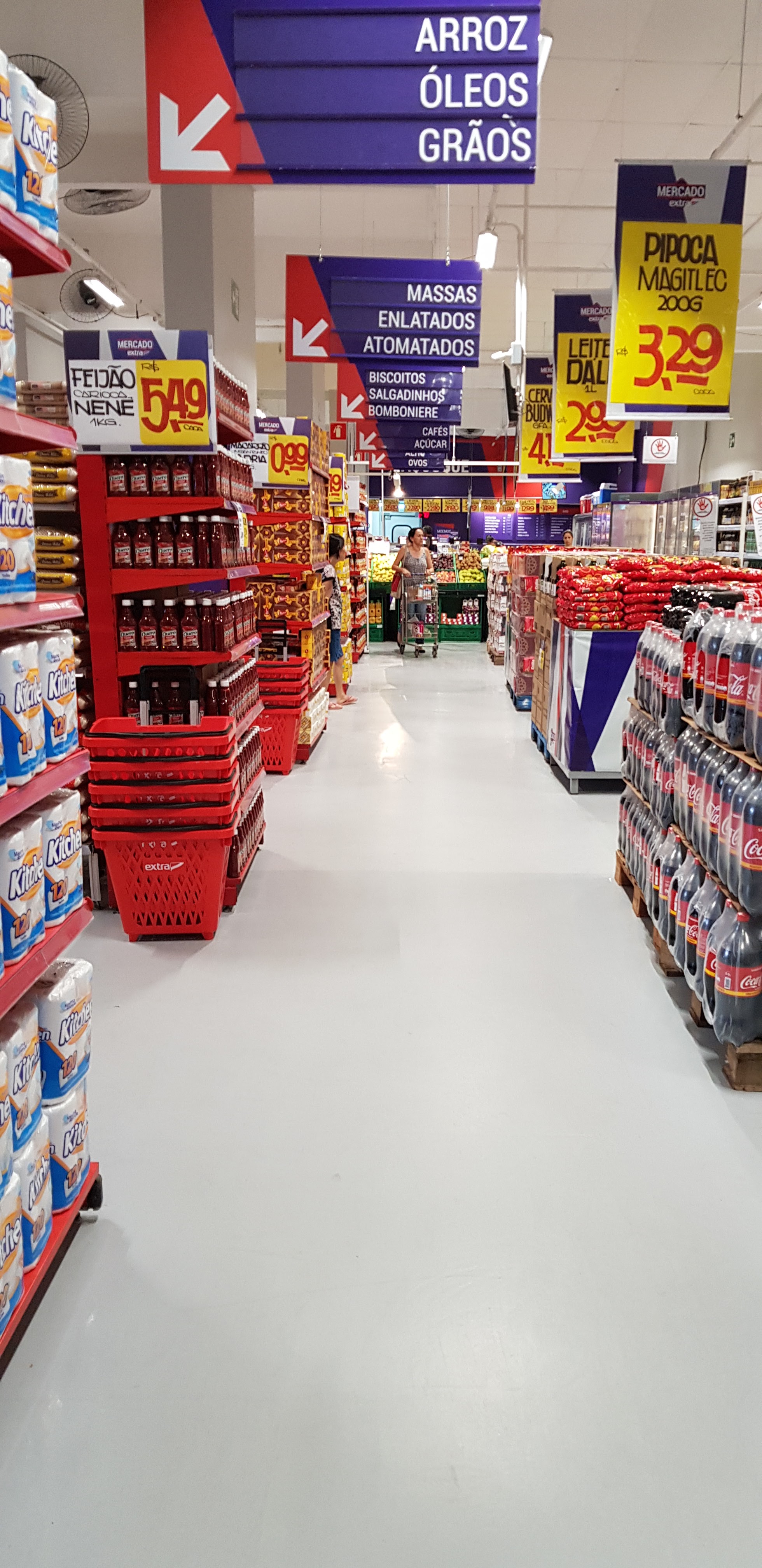 Piso autonivelante cinza aplicado em corredor de supermercado, acabamento contínuo e refletivo.