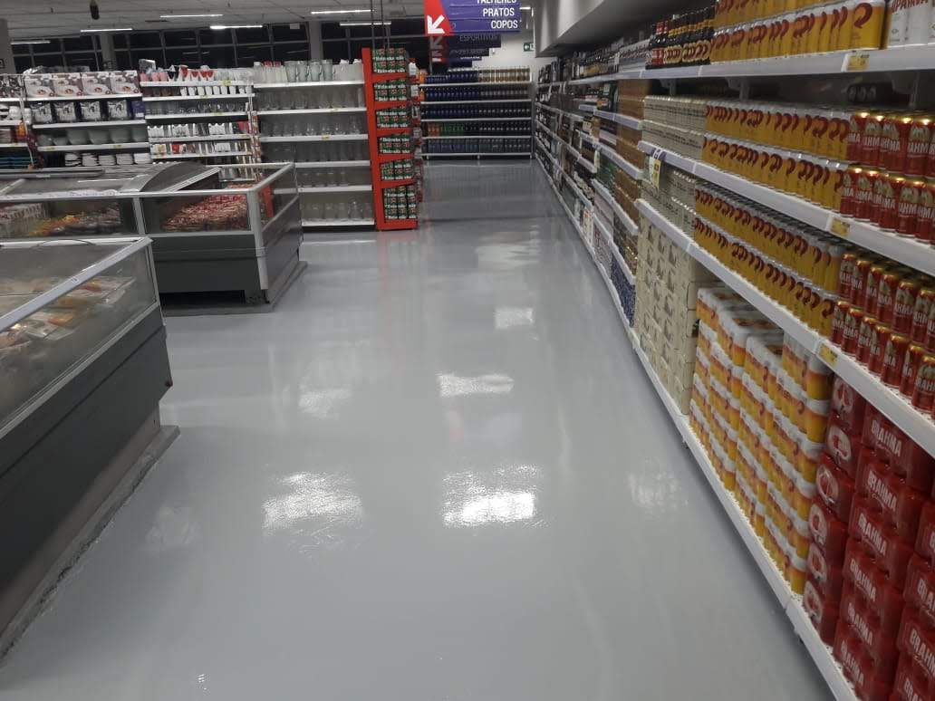 Detalhe de piso autonivelante em área de venda de supermercado, acabamento uniforme e de fácil limpeza.
