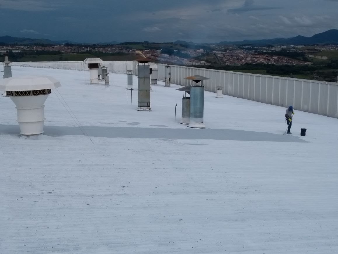 Trecho de telhado metálico corrugado ainda oxidado e desgastado, aguardando aplicação do sistema impermeabilizante.