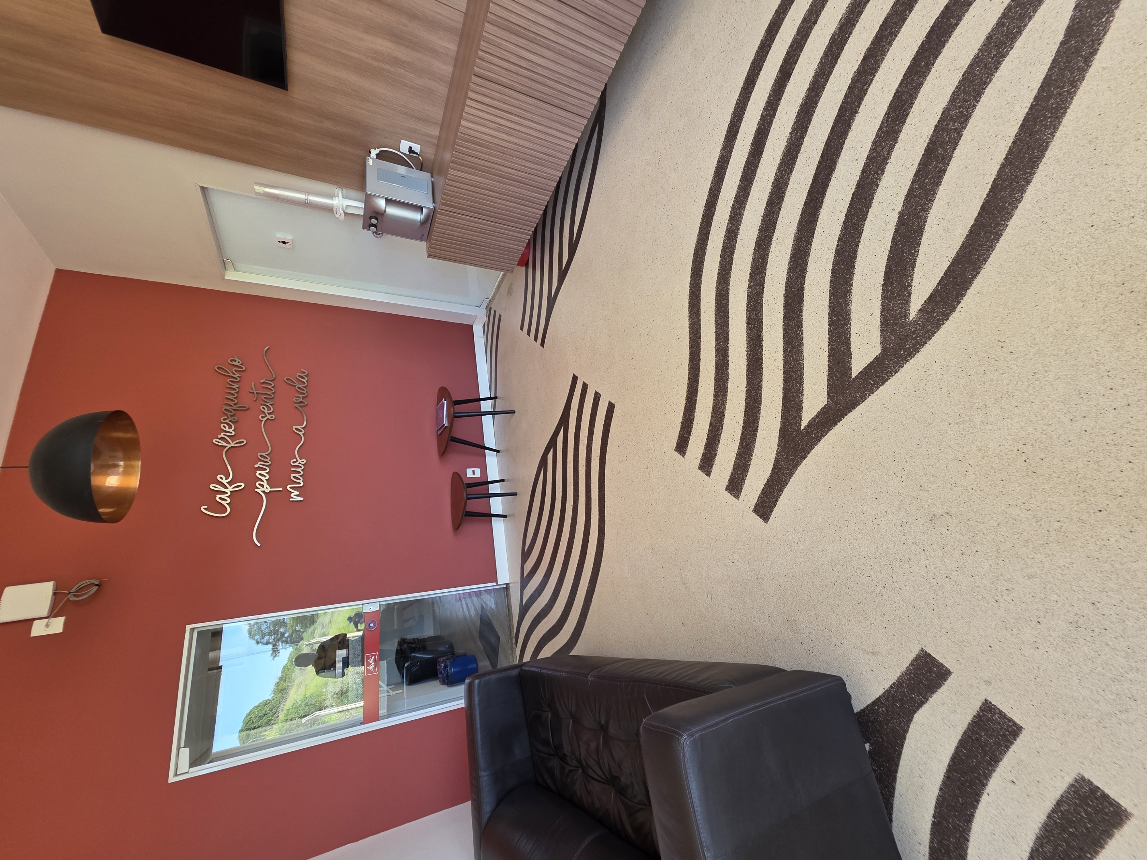 Detalhe do piso decorativo com desenho de ondas escuras traçadas sobre base bege texturizada.