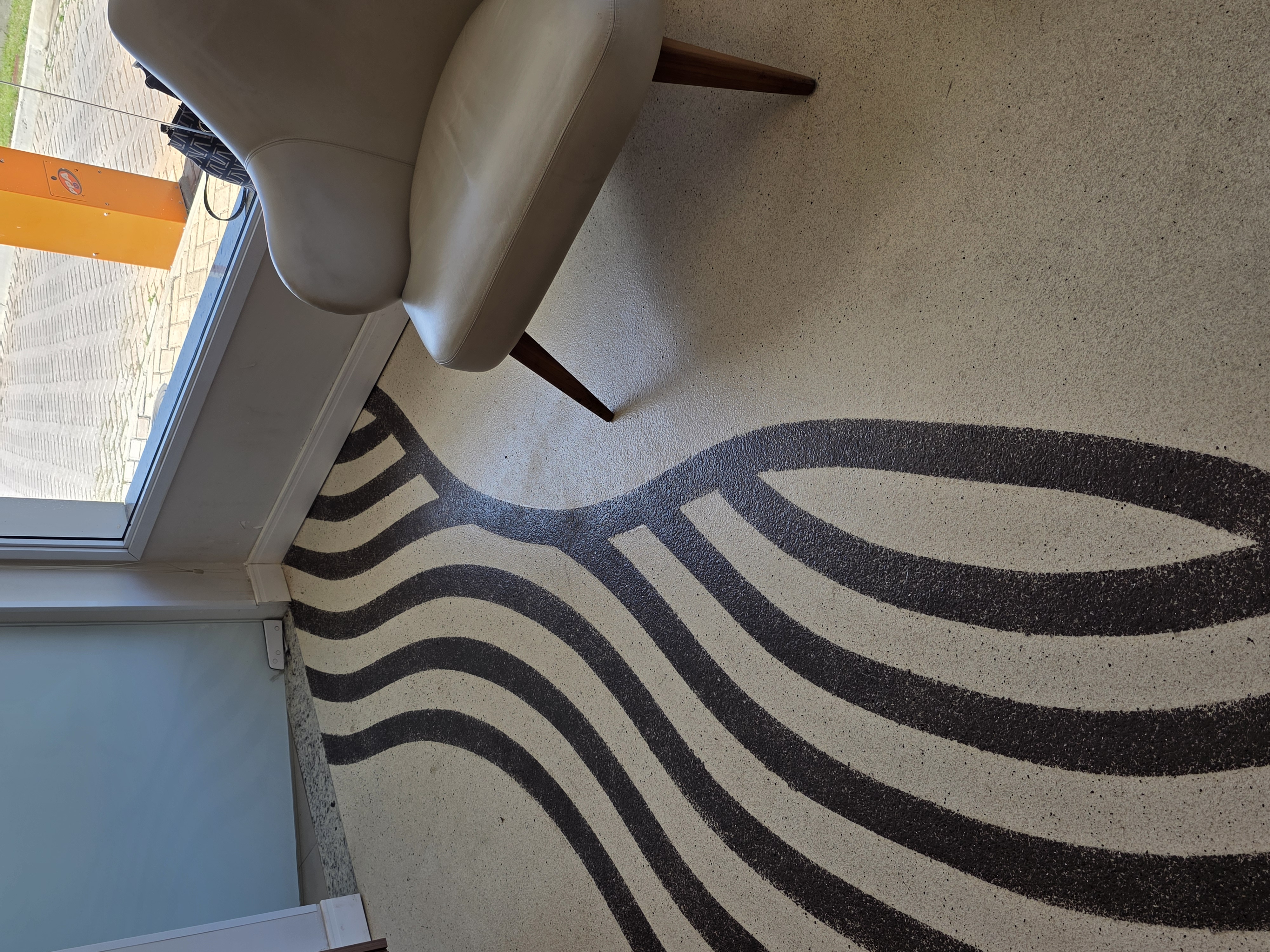 Piso decorativo ondulado finalizado em ambiente comercial, com poltronas de couro e iluminação ambiente.