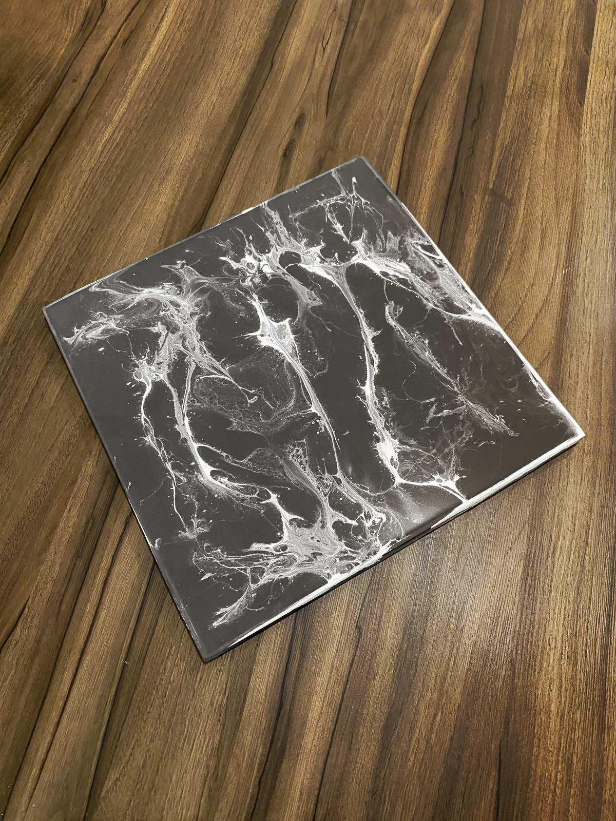 Amostra de piso epóxi 3D com efeito marmorizado artístico, demonstrando variação de cor e textura possível na personalização.
